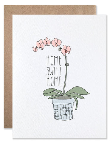 Neon pink orchid plant in a blue pot with Home Sweet Home written to the left of the plant